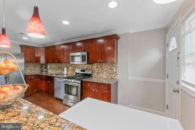 a kitchen with stainless steel appliances granite countertop a refrigerator sink and stove