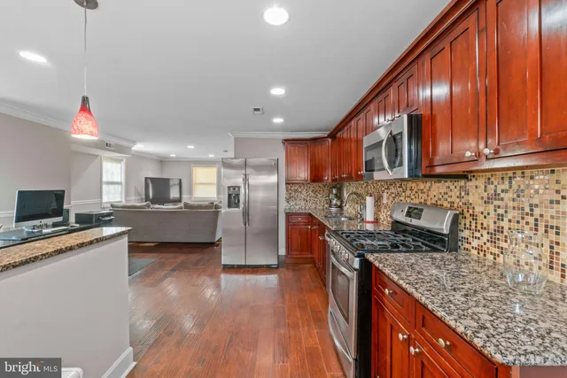 a kitchen with stainless steel appliances granite countertop a sink stove and cabinets