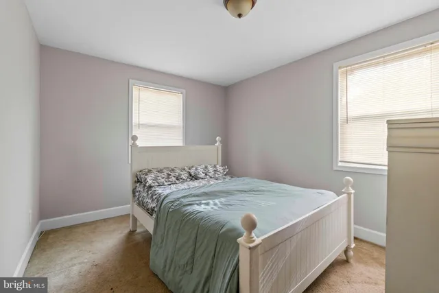 a bed sitting in a bedroom next to a window