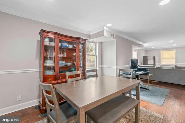 a living room with dining table and wooden floor