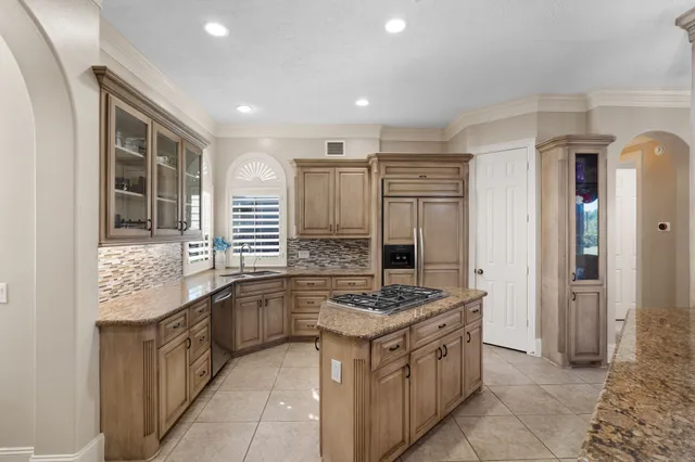 a kitchen with stainless steel appliances granite countertop a sink stove and cabinets