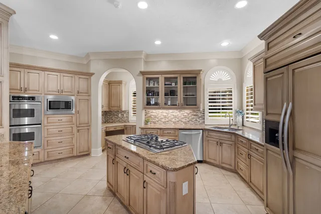 a kitchen with stainless steel appliances granite countertop a stove refrigerator and cabinets
