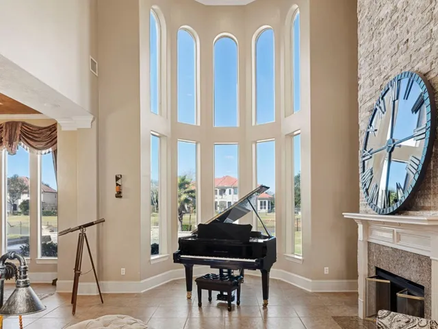 a living room with furniture a fireplace and a floor to ceiling window