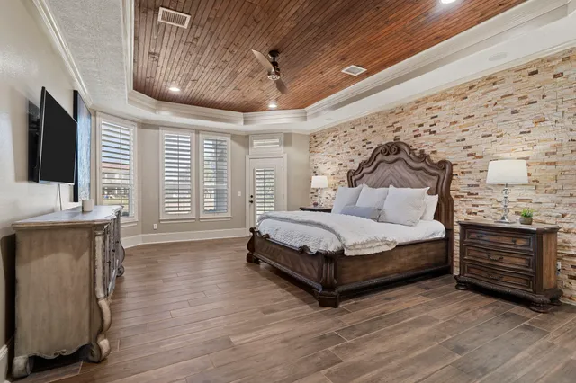 a bedroom with a bed and a flat tv screen on dresser
