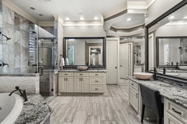 a large bathroom with a granite countertop sink large mirror and shower