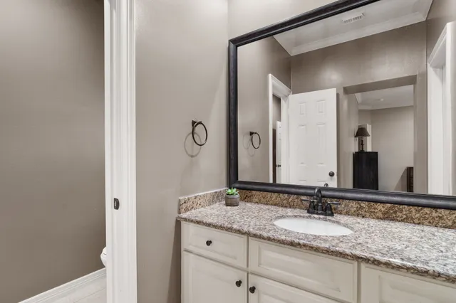 a bathroom with a granite countertop sink and a mirror