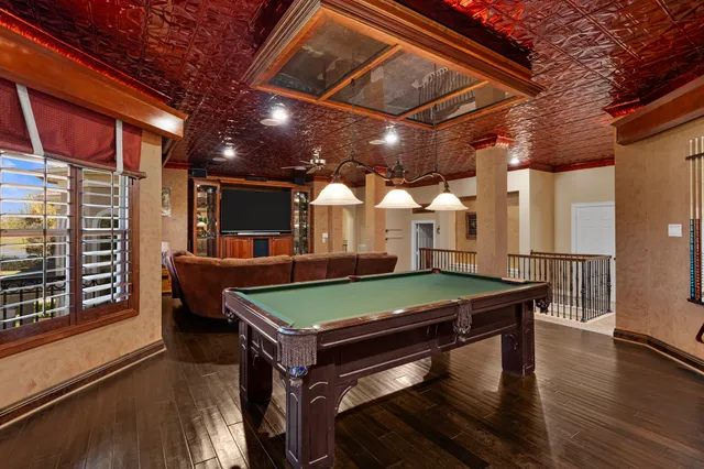 a room with pool table and windows
