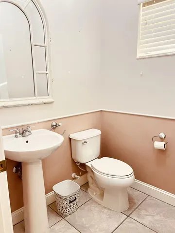 a bathroom with a sink toilet and a mirror