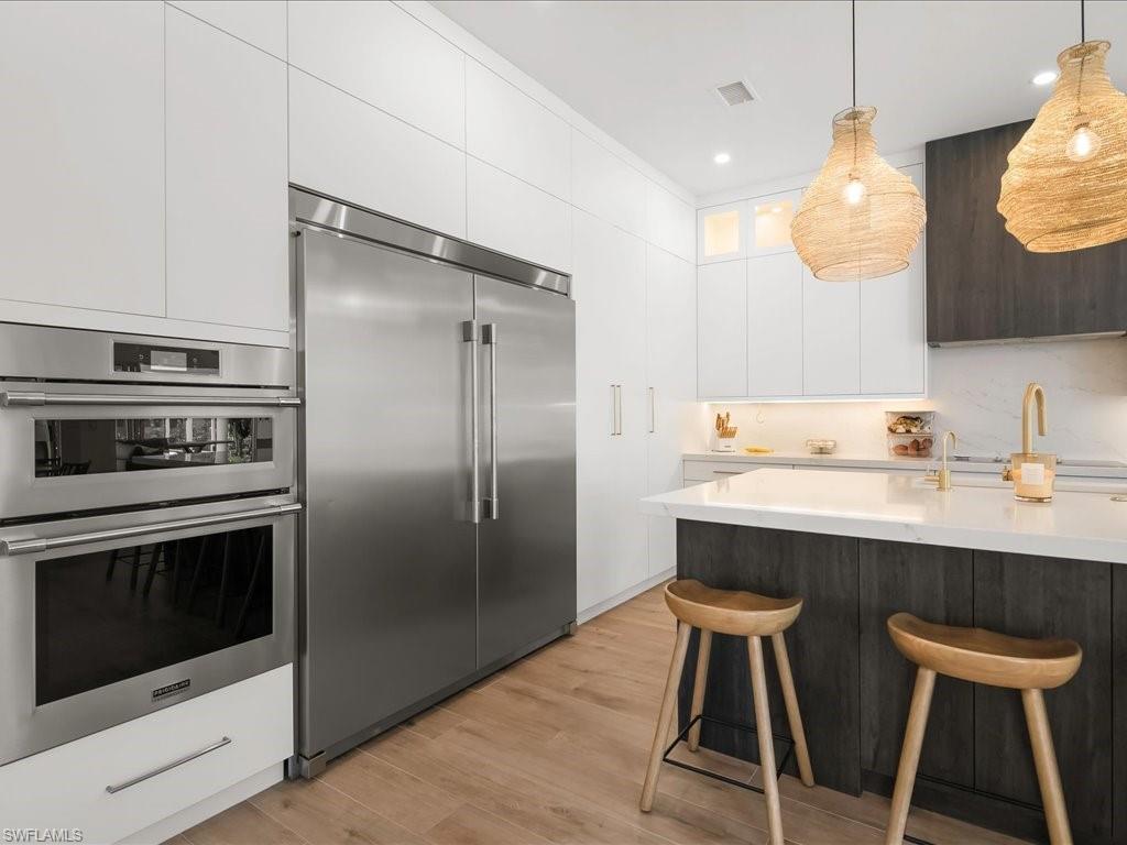 2115 Imperial Golf Course Boulevard Naples, FL 34110 - Photo 11 of 50 a kitchen with stainless steel appliances a stove a sink and a refrigerator