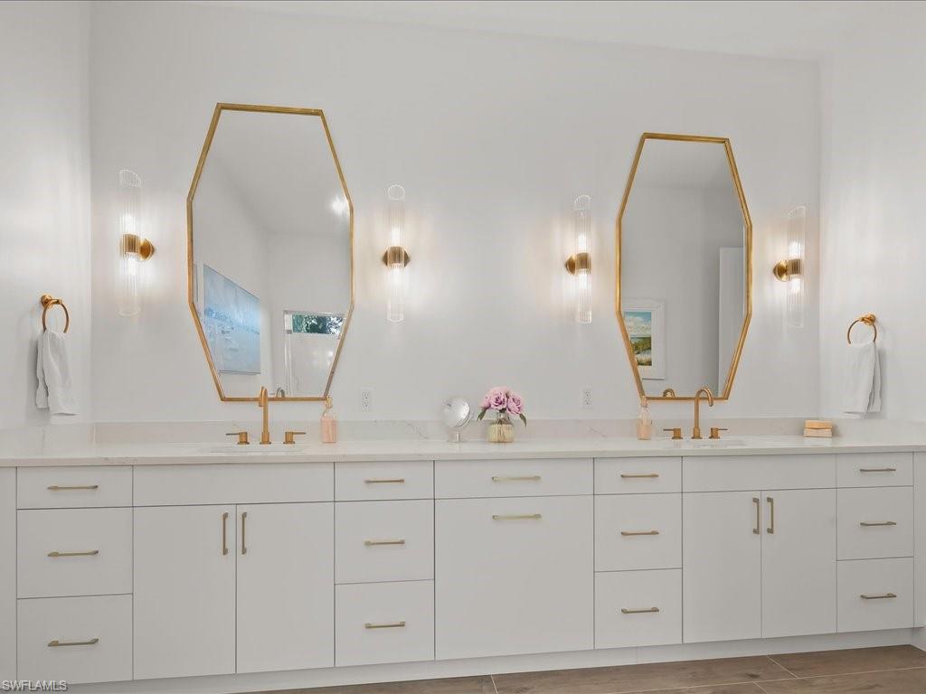 2115 Imperial Golf Course Boulevard Naples, FL 34110 - Photo 21 of 50 a bathroom with a double vanity sink and a mirror