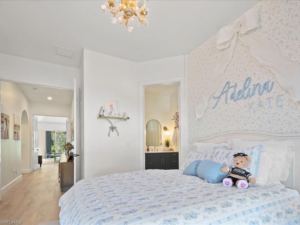 2115 Imperial Golf Course Boulevard Naples, FL 34110 - Photo 25 of 50 a bedroom with a bed and a chandelier