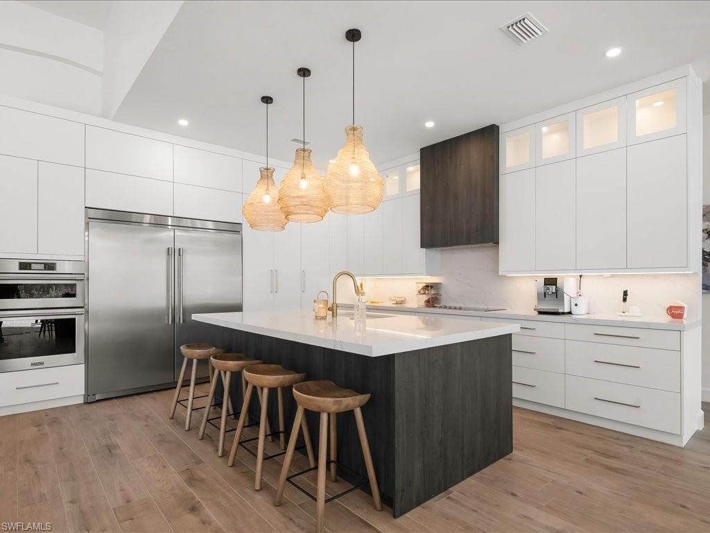 2115 Imperial Golf Course Boulevard Naples, FL 34110 - Photo 4 of 50 a kitchen with a sink a center island stainless steel appliances and cabinets