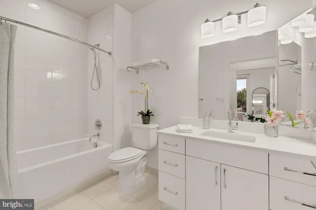 a bathroom with a double vanity sink toilet mirror and shower