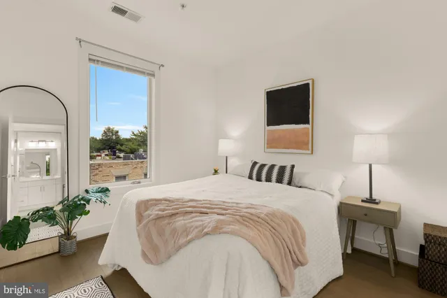 a bedroom with a bed and a potted plant