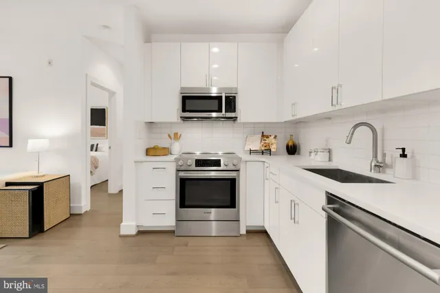 a kitchen with white cabinets and stainless steel appliances