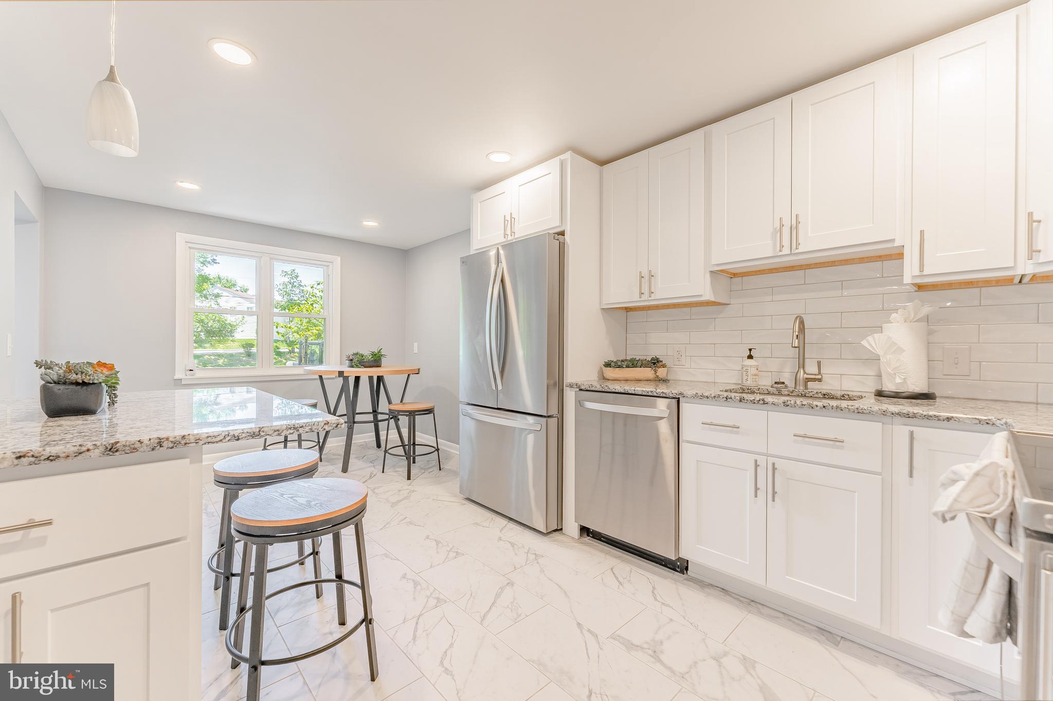 515 Park Road Spring City, PA 19475 - Photo 19 of 38 a kitchen with stainless steel appliances granite countertop a stove a sink a refrigerator and white cabinets with wooden floor