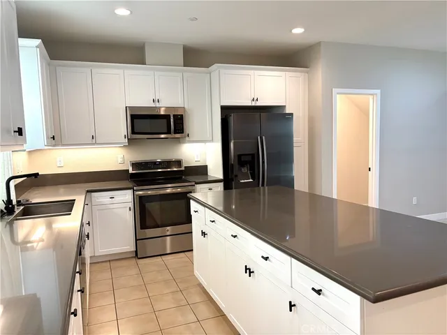 a kitchen with granite countertop white cabinets and stainless steel appliances