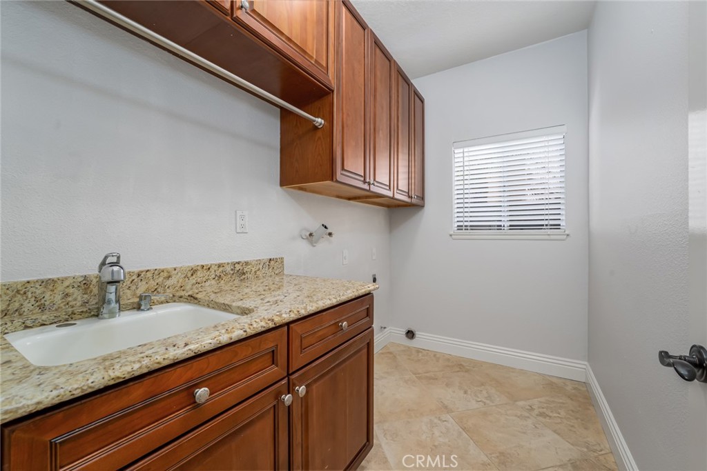19 Springbrook Road Laguna Niguel, CA 92677 - Photo 31 of 50 a kitchen with granite countertop a sink a stove and cabinets