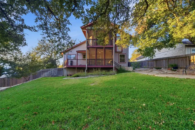 a view of a house with backyard and a tree