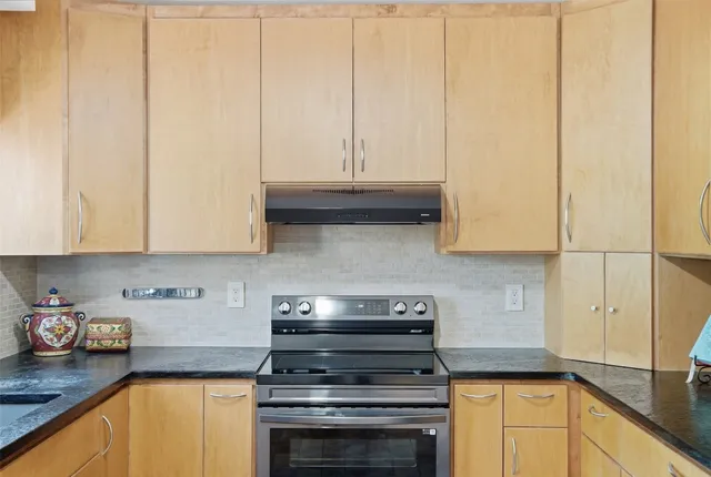 a kitchen with granite countertop white cabinets and stainless steel appliances