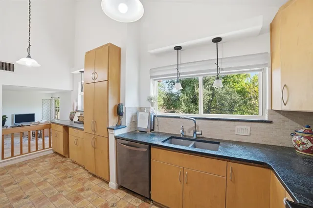 a kitchen with stainless steel appliances granite countertop a refrigerator a sink and white cabinets