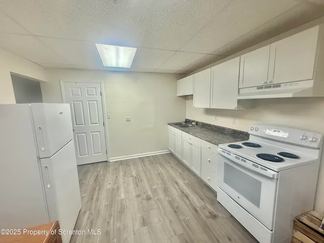 a view of kitchen with a sink refrigerator and window