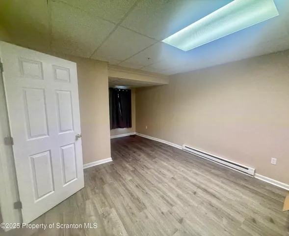 a view of an empty room with wooden floor