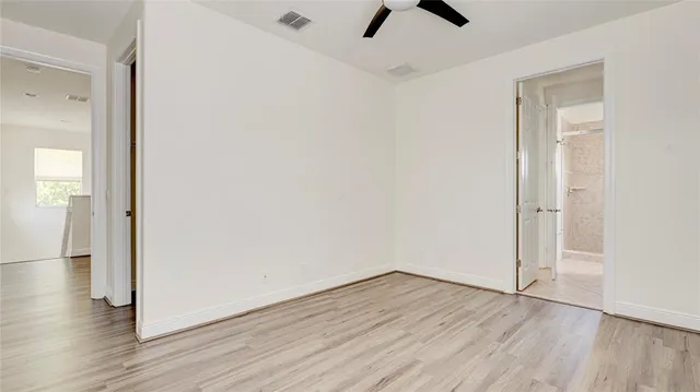 an empty room with wooden floor and window