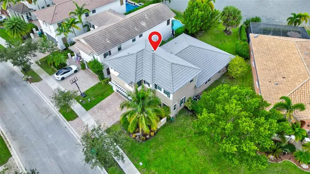 an aerial view of residential houses with outdoor space and trees
