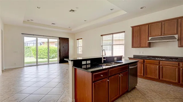 a kitchen with granite countertop a sink stove and refrigerator