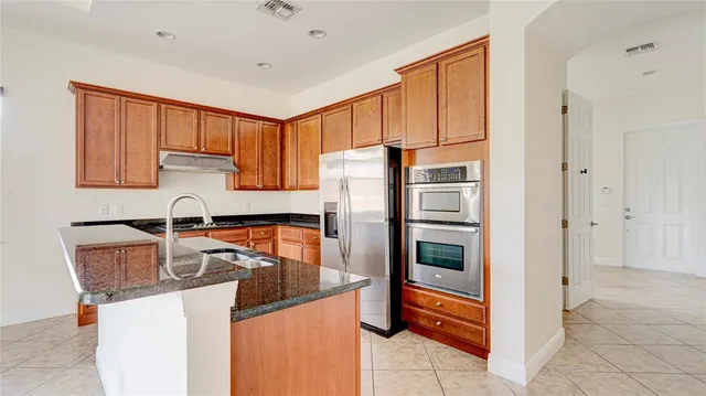 a kitchen with granite countertop cabinets and a stove top oven