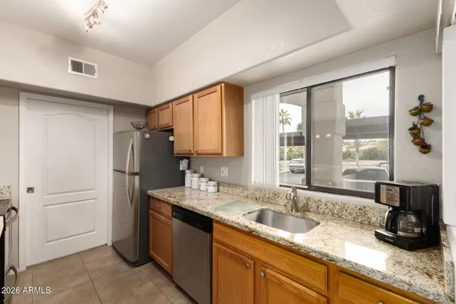 a kitchen with stainless steel appliances granite countertop a sink stove and refrigerator