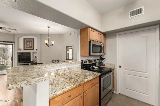 a kitchen with granite countertop a sink and a stove top oven