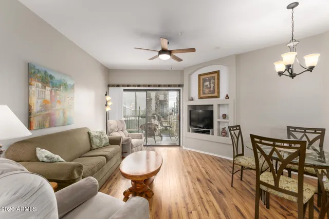 a living room with furniture a flat screen tv and a chandelier