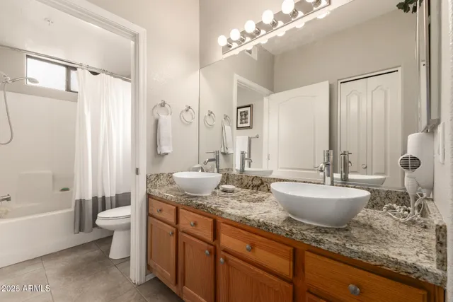 a spacious bathroom with a granite countertop sink mirror and toilet