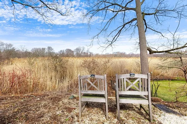 a view of a lake with a bench under an umbrella