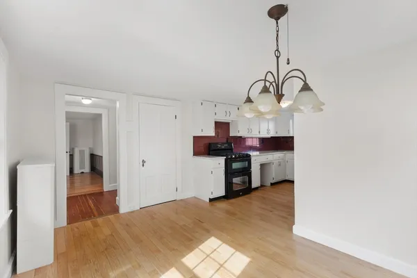 a kitchen with stainless steel appliances granite countertop a sink dishwasher a stove and a refrigerator with wooden floor