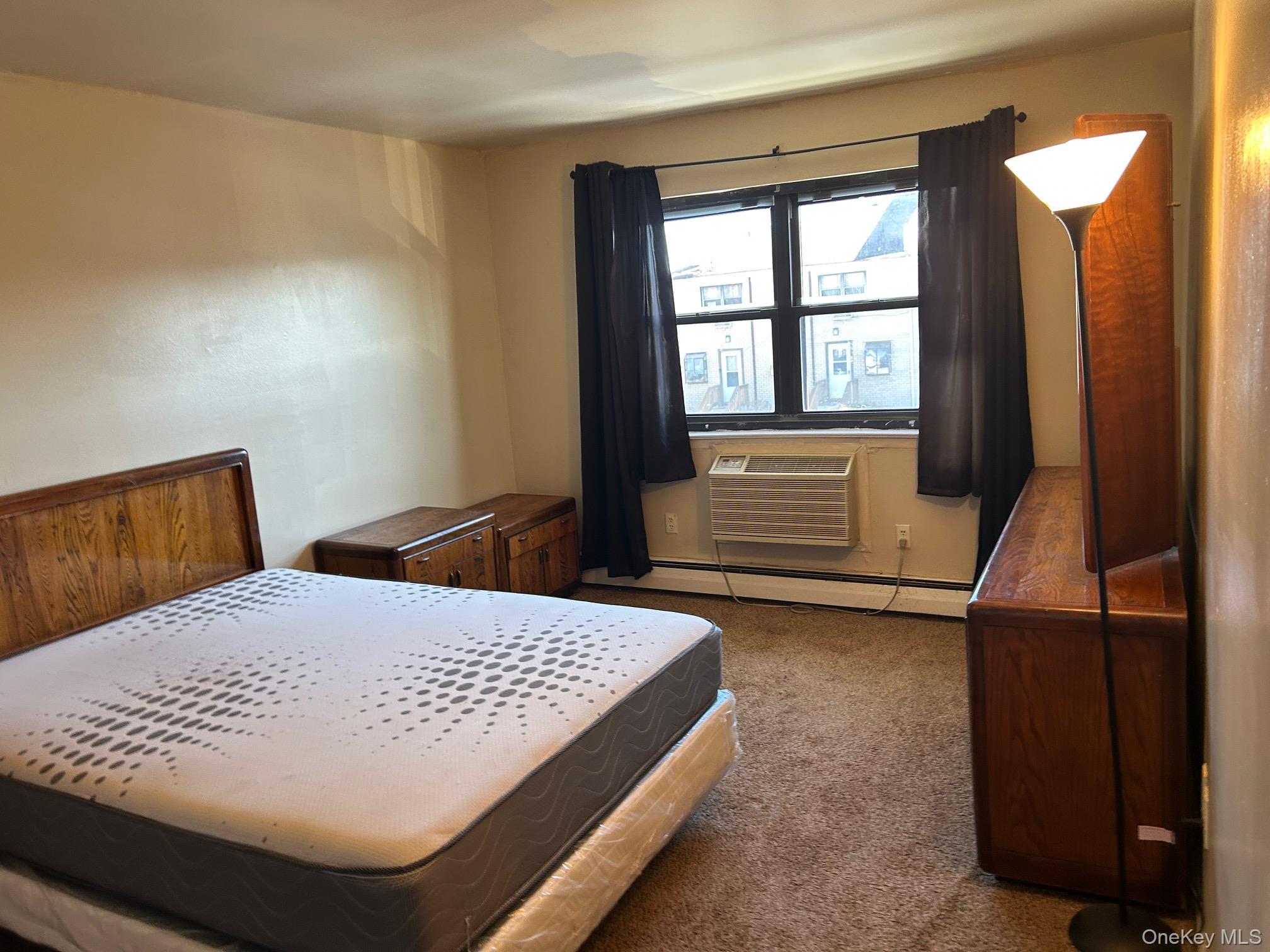 68 Sneden Place West, Unit 68 Spring Valley, NY 10977 - Photo 14 of 24 Carpeted bedroom with a baseboard radiator and a wall mounted AC