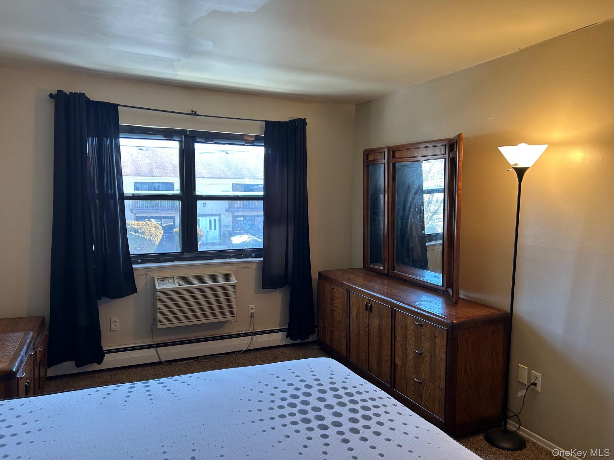 68 Sneden Place West, Unit 68 Spring Valley, NY 10977 - Photo 17 of 24 Bedroom with baseboard heating, multiple windows, and a wall mounted AC