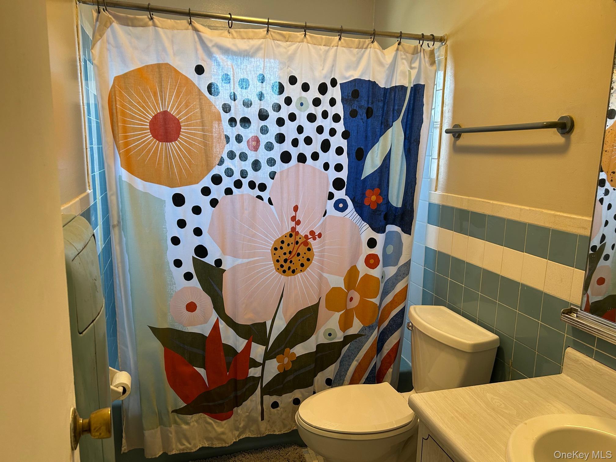 68 Sneden Place West, Unit 68 Spring Valley, NY 10977 - Photo 19 of 24 Bathroom with tile walls, vanity, and a wainscoted wall