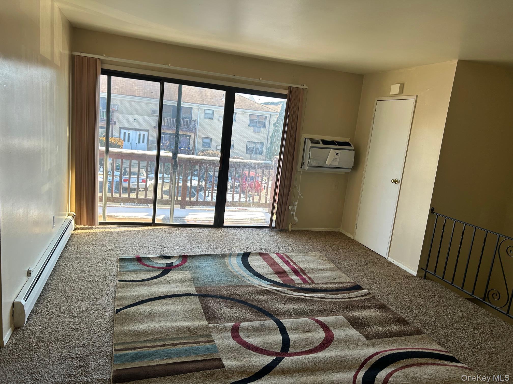 68 Sneden Place West, Unit 68 Spring Valley, NY 10977 - Photo 5 of 24 Empty room featuring a baseboard radiator and carpet flooring