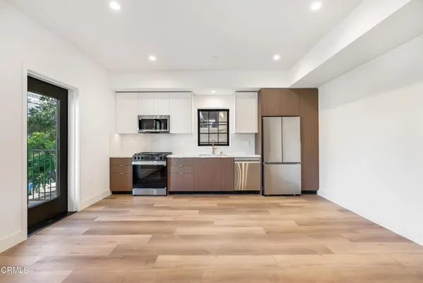 a view of kitchen with stainless steel appliances granite countertop a refrigerator and a sink