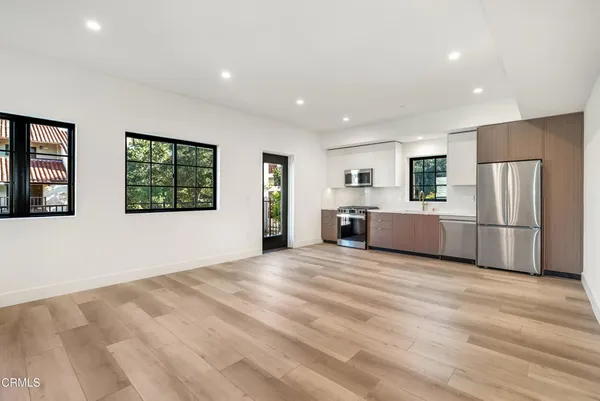 a view of a kitchen with refrigerator and windows