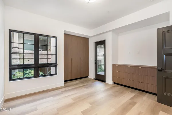 a view of an empty room with window cabinet and refrigerator