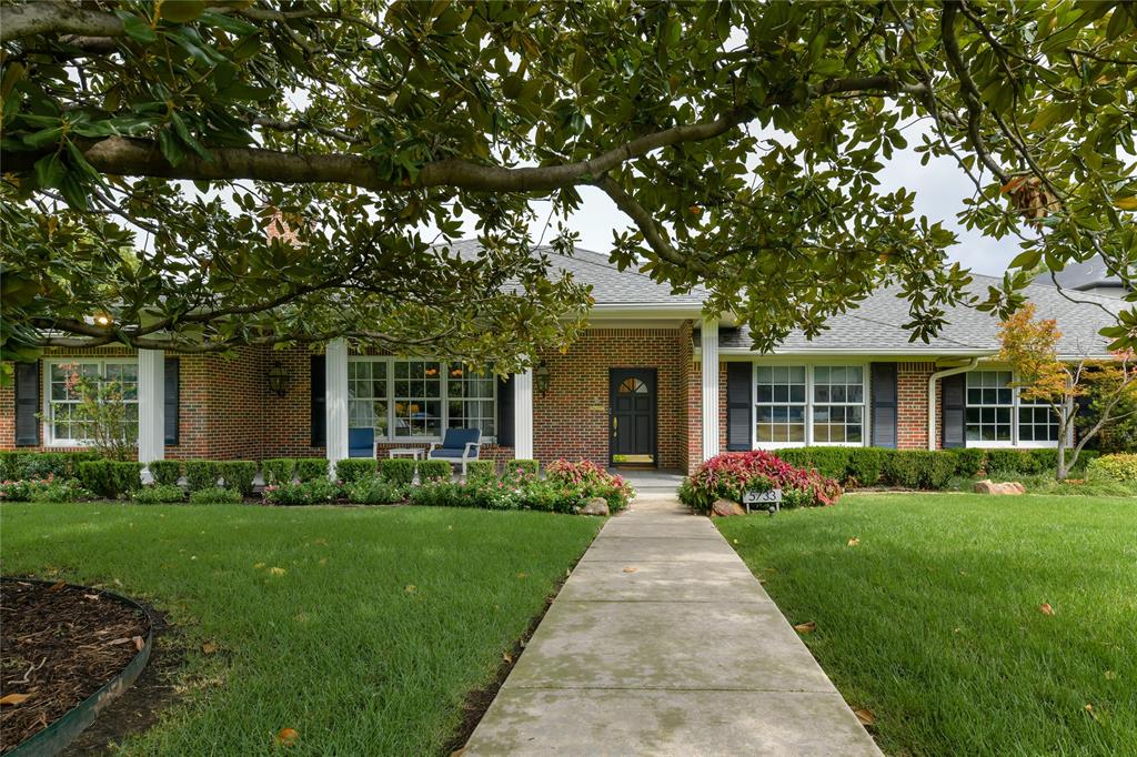 5733 Stonegate Road Dallas, TX 75209 - Photo 1 of 1 a front view of a house with a garden and trees