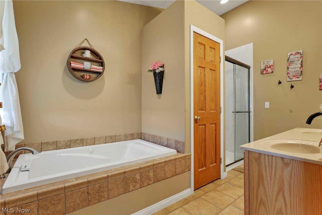 3483 Cooper Road Cumberland, OH 43732 - Photo 13 of 50 Bathroom featuring tile flooring, vanity, and independent shower and bath