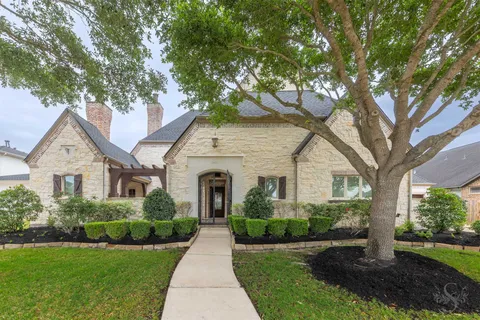 a front view of a house with a yard and potted plants