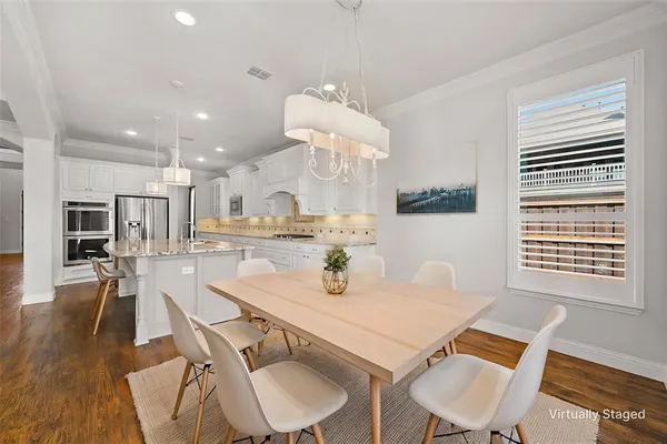 a view of a dining room with furniture wooden floor and chandelier