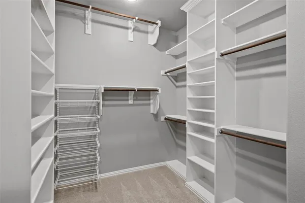 a view of walk in closet with empty racks