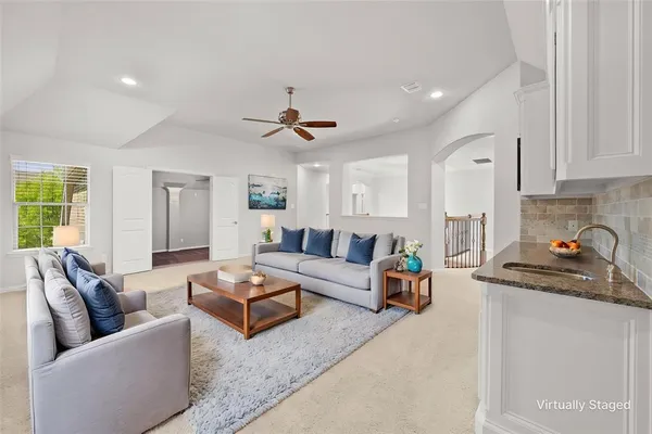 a living room with furniture and kitchen view